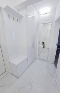 瓦尔纳Nova City Apartments的白色的浴室设有白色的墙壁和镜子