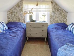 乌拉勒德Holiday home ULLARED的卧室设有两张床铺、蓝色床单和梳妆台