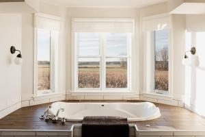 皮克顿Fox Lane - Prince Edward County Farmhouse的带窗户的客房内的白色浴缸