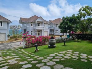 美奈Villa Sea View Phan Thiet Mui Ne的一座白色的大房子,带鲜花的院子