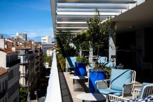 土伦OKKO Hotels Toulon Centre的大楼内的阳台配有蓝色的桌椅