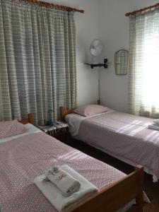ÓrmosSeaby Apartment的一间卧室设有两张床,窗户配有窗帘