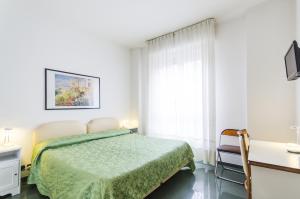 米兰莫里斯酒店的一间卧室配有一张床、一张书桌和一个窗户。