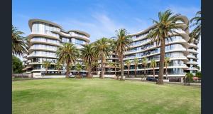 墨尔本Chic St Kilda Retreat, Close to Beach & Eats的一座棕榈树环绕的大建筑