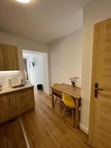 弗罗茨瓦夫SZWEDZKA22 PL Premium Rooms的厨房铺有木地板,配有木桌。