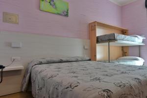 西尔米奥奈费奥达里索酒店的一间卧室配有一张床和粉红色的墙壁