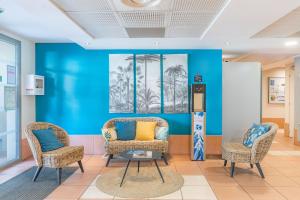 拉西约塔Appart'City Confort La Ciotat - Côté Port的一间设有两把椅子和蓝色墙壁的房间