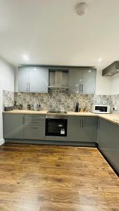曼彻斯特UR PLACE的厨房配有不锈钢用具,铺有木地板