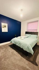曼彻斯特UR PLACE的一间卧室配有一张蓝色墙壁的床