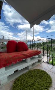 吉诺卡斯特Marko's House的阳台上配有带两个红色枕头的长凳