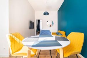 瓦朗西纳Suite Cosy MontBlanc en Hyper Centre的一间带桌子和黄色椅子的用餐室