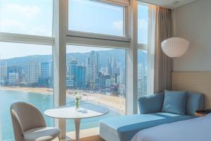 釜山Hotel Marine view的一间卧室配有一张床、一张桌子和一个窗户。