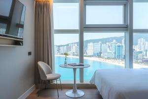 釜山Hotel Marine view的酒店客房设有床、桌子和窗户。