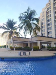 波拉马尔Ocean Blue的一座棕榈树环绕的建筑,位于游泳池前