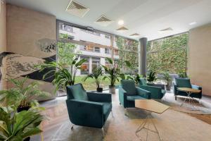 布达佩斯Bliss Residence & Spa的一间拥有绿色椅子和植物的等候室