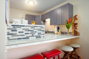 希洛Hualalai 307 Thirty One Day Minimum的厨房配有蓝色橱柜和红色凳子