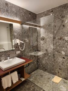 多比亚科Hotel Dolomiten的一间带水槽和淋浴的浴室