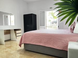 卡尼萨尔Studio Home Away from Home的一间卧室配有一张床、一张桌子和植物