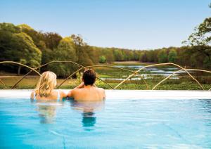 TrensumEriksberg Hotel & Nature Reserve的坐在游泳池里的男人和女人