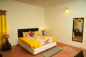 马迪凯里Copperhill- A Luxury Homestay的一间卧室配有一张带黄色床单和镜子的床