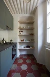 瓦伦纳Fisherman's house n.3的厨房铺有红色和白色的瓷砖地板。