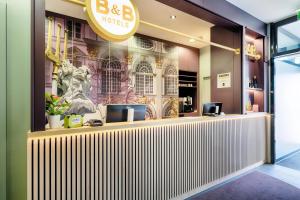 慕尼黑B&B Hotel München-Moosach的墙上有标牌的餐厅内的酒吧