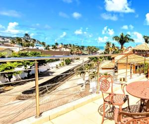 瓜鲁雅Hotel Rosa da Ilha - Pertinho do Mar com piscina的阳台配有桌椅,享有海景。