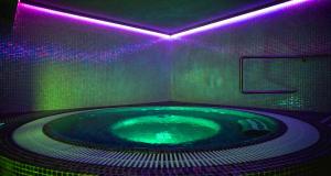 切霍齐内克TeoDorka Med & SPA的浴室配有带紫色灯的热水浴池