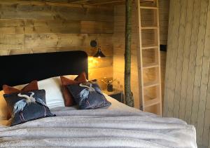 奥克姆Old Oak Farm的一间卧室配有带枕头的床铺和书架