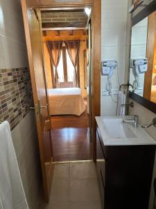 塞哥维亚Hostal segovia adults only的一间带水槽的浴室和一张位于客房内的床