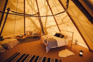 伊费林赫利GreenWood Family Park的帐篷内的卧室,配有一张床