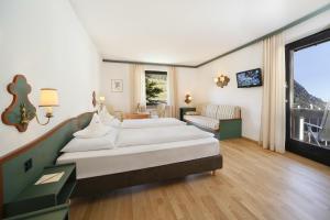 拉古多Parkhotel Tirolerhof的一间带两张床的卧室和一间客厅