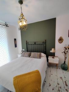 科瓦莱达Covaleda naturazleza y relax的卧室配有一张白色大床和吊灯。