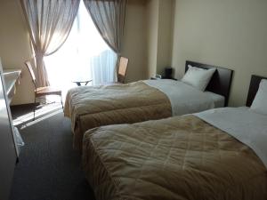 富士河口湖SAWA酒店的酒店客房设有两张床和窗户。