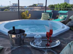 里米尼梅莫里酒店的热水浴池配有1杯葡萄酒和酒杯