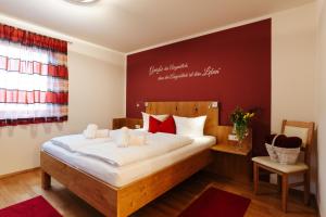 特洛普拉赫Burgls Apartmenthaus的一间卧室配有带白色床单和红色枕头的床。