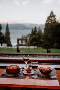 圣卡洛斯-德巴里洛切Basia Hotel & Sushi的一张桌子,上面放着两杯葡萄酒和食物