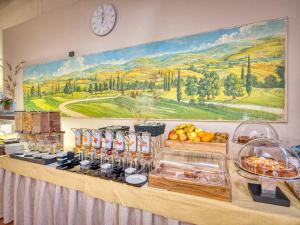 佩斯基耶拉德加达活力帕拉迪索高尔夫酒店的自助餐,包括食物和墙上的时钟