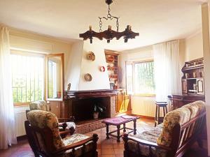 圣彼得罗镇Casa Azzurra的客厅设有壁炉、椅子和吊灯。