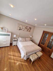 卡马乔Apartamento constitución的卧室配有白色的床,铺有木地板