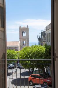 陶尔米纳Castalia Apartments & Rooms Duomo Taormina的从带钟楼街道的窗户欣赏风景