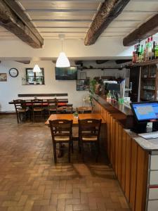 台格纳Ristorante della Stazione的一间带木桌椅的餐厅和一间酒吧