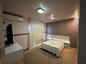波多韦柳Pousada Residencial - PVH的一间小卧室,配有一张床和电视