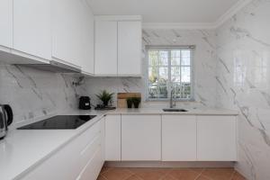 维拉摩拉NEW LISTING - Eden Villas的白色的厨房配有白色橱柜和窗户