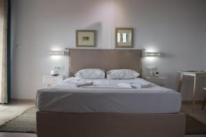 Kalamaki MessiniaAlexandros Apartments & Αλέξανδρος Villas的卧室内的一张带白色床单和枕头的床