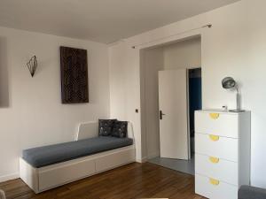 巴黎Studio perfect for 2 adults and 1 kid, and up to 2 kids - Jourdain 20e, 25mn to Louvre via line M11的一间小卧室,配有一张床和一个梳妆台