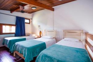 马利西亚斯Pousada Azul Banana - Maresias的一间卧室配有两张带蓝白色床单的床