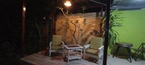 马尔多纳多港koryares haushostel的庭院里摆放着一组椅子和一张桌子