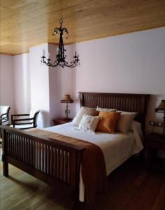 洛维奥斯Casa Rosalia的一间卧室配有一张大床和一个吊灯。