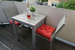 奥斯赛拜-屈隆斯博恩Ferienanlage-Reriker-Strasse-OG-links-721的桌子和两把椅子,带酒杯和一瓶